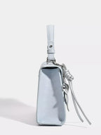 Light blue mini handbag with silver leaf charm and tassel, trendy fashion accessory