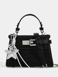 Black textured handbag with silver star charm, top handle, and chain strap, fashion accessory