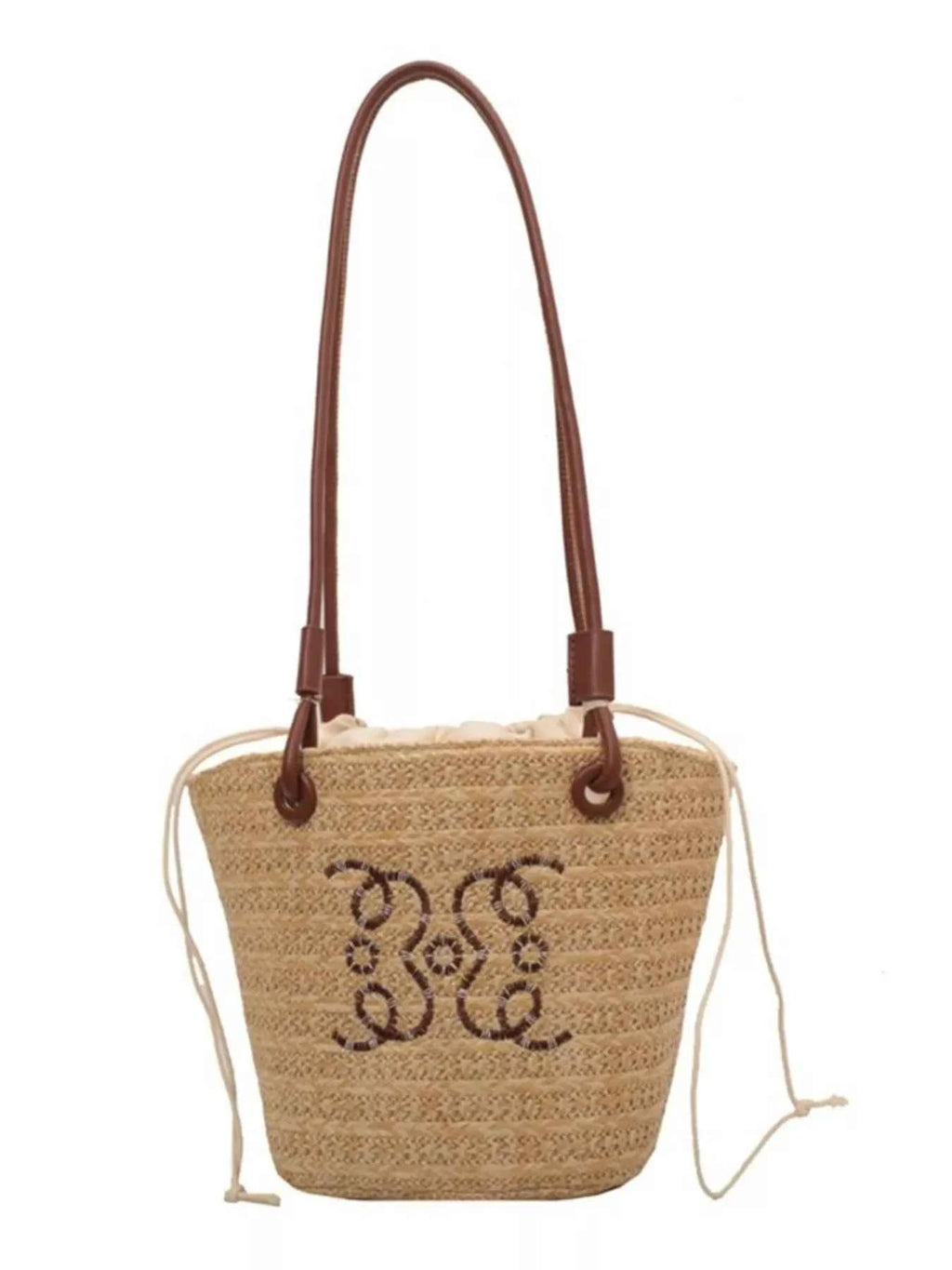 Straw tote bag with brown leather handles and embroidered floral design, perfect for summer fashion.