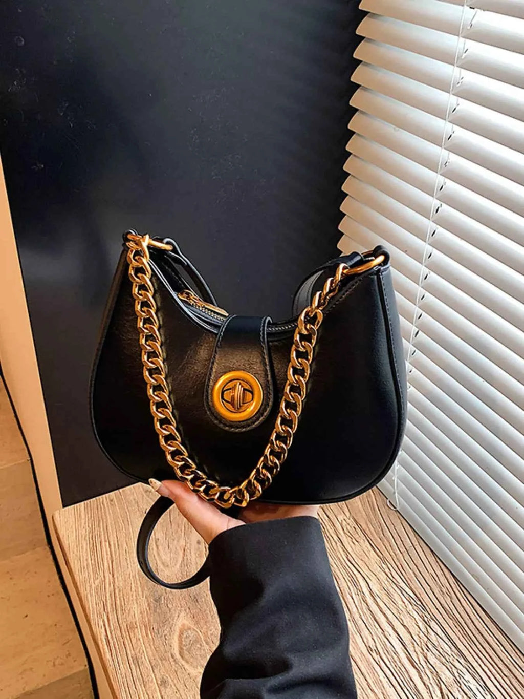 Black crescent moon bag with gold chain strap, luxury fashion accessory for women